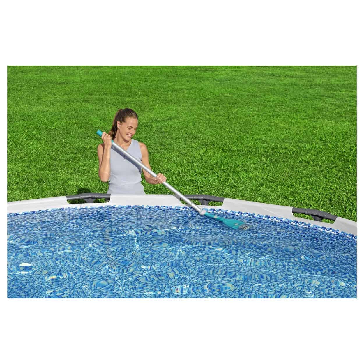 Vrouw gebruikt elektrische zwembadstofzuiger voor schoonmaken van zwembad.