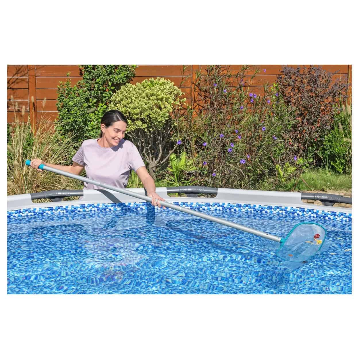 Vrouw gebruikt zwembadstofzuiger voor schoonmaak in tuinzwembad.