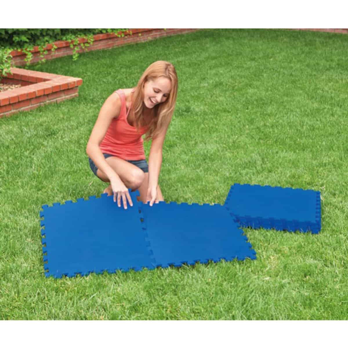 Kind dat opblazen en uitvouwen opblaasbare zwembadmat in de tuin.
