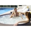 Man en vrouw genieten van een hottub met drankjes in de tuin.