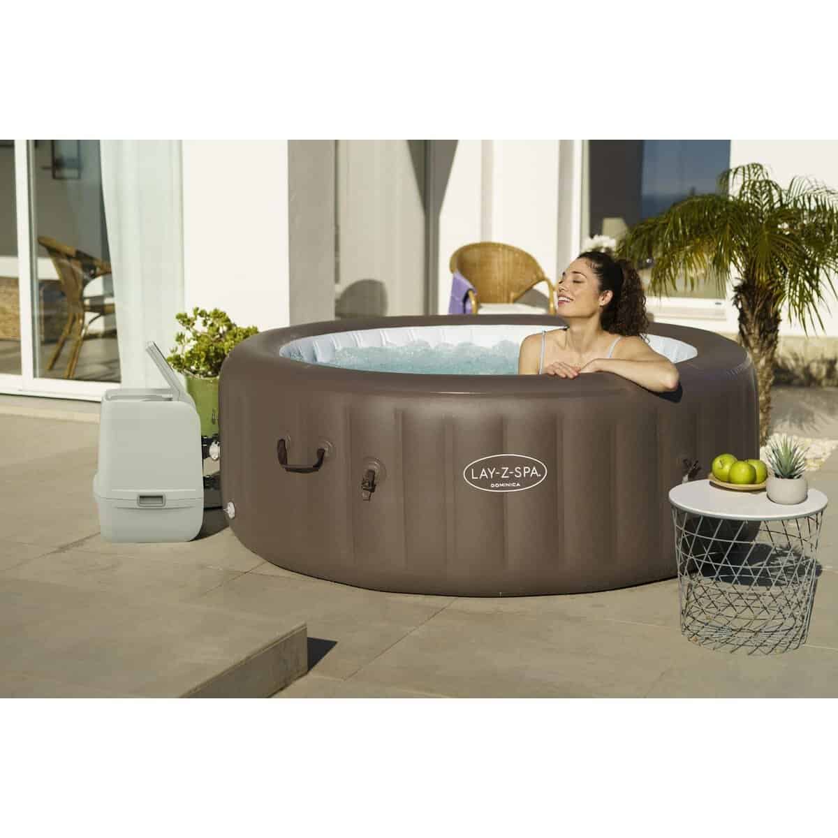 Opblaasbare jacuzzi voor buitengebruik met vrouw die geniet van een warm bad.