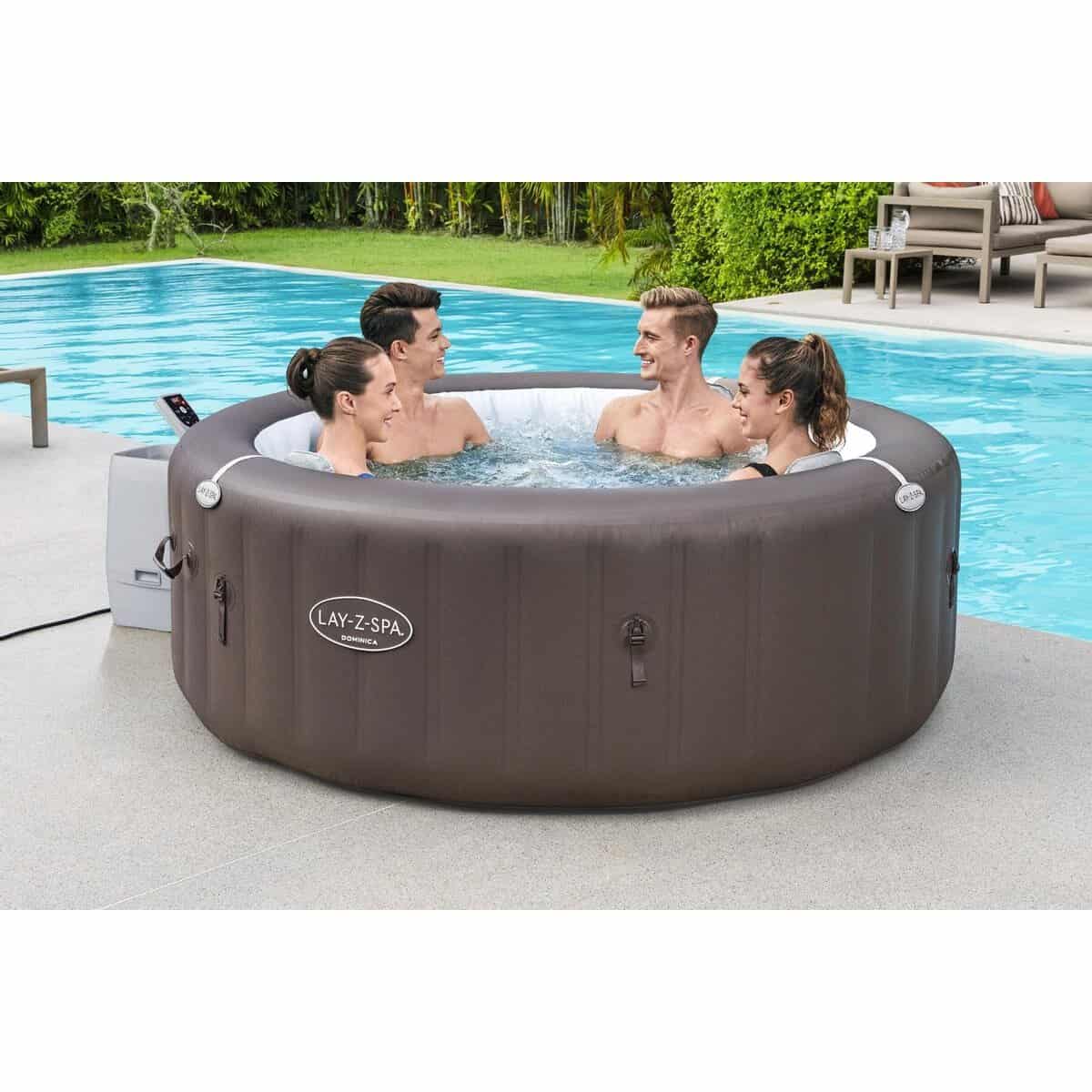 Opblaasbare hottub met vier mensen die genieten in de tuin.