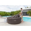 Man vult opblaasbare jacuzzi met water naast zwembad in tuin.