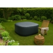 Opblaasbaar hottub in tuin met zitje en groene planten.
