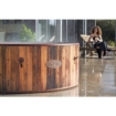 Houten hottub voor buitengebruik met vrouw die ontspant op ligstoel.