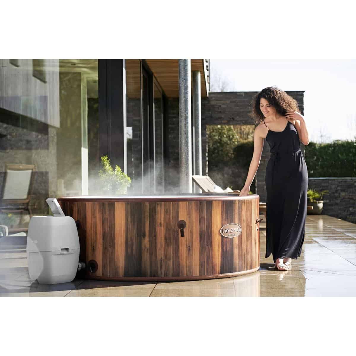 Luxe houten hottub buiten met stoom, vrouw genietend van ontspanning.