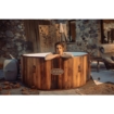 Houten hottub in tuin met vrouw die ontspant en geniet van rust.