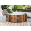 Luxe houten hottub op terras met groene tuin en bloemen.