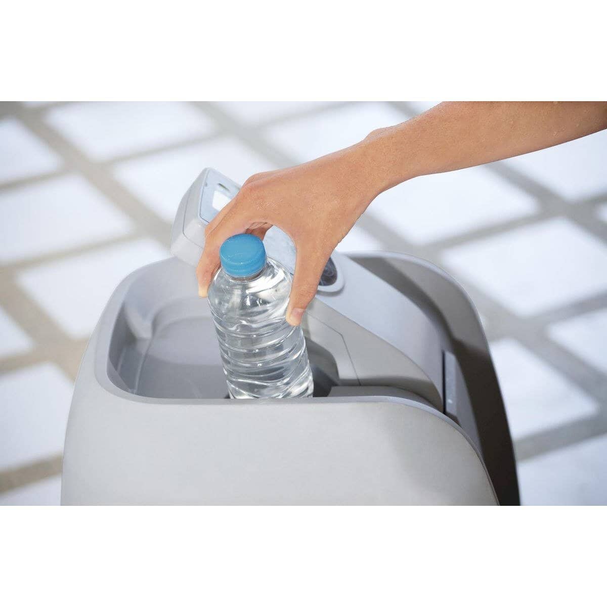 Hand vult waterfles met water in waterfilterapparaat.