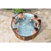 Gezellig bad in de tuin met zes mensen die samen ontspannen en genieten van een drankje in het water.