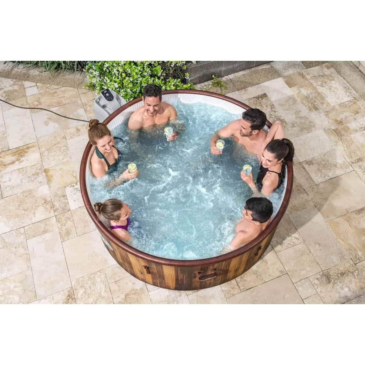 Gezellig bad in de tuin met zes mensen die samen ontspannen en genieten van een drankje in het water.