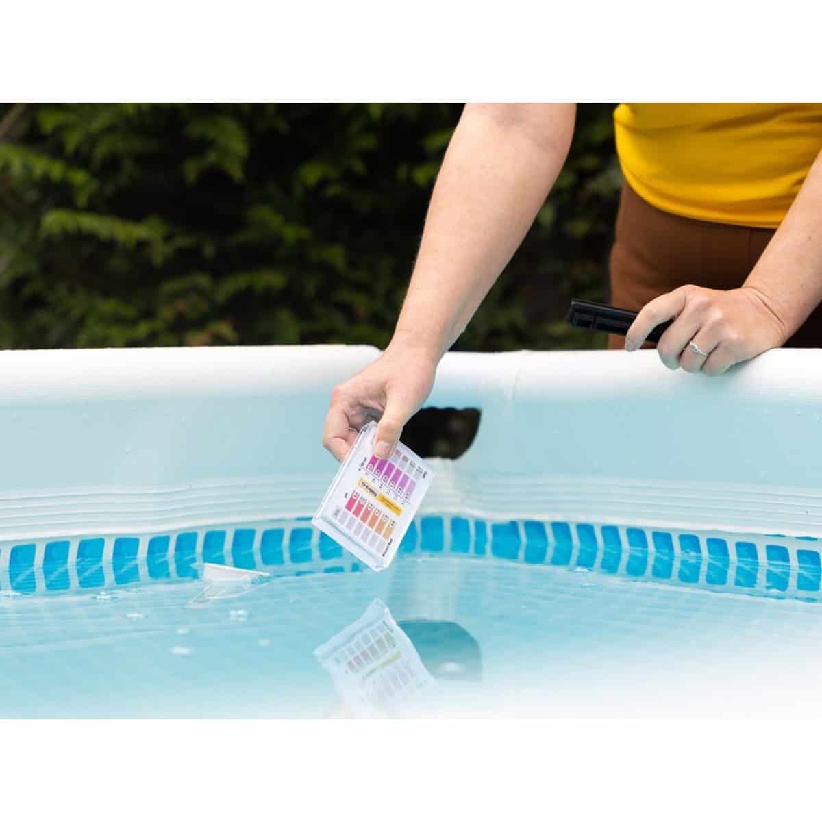 Teststrips voor zwembadwatercontrole in gebruik.