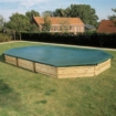 Zwembad met houten frame en afdekzeil in tuin.